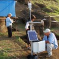 Conservation scientist Christian Fischer downloading data from environmental monitoring equipment. Moai 157 has already been covered to protect it from the elements.  Monica Bahamondez P. and Jo Anne Van Tilburg in background.